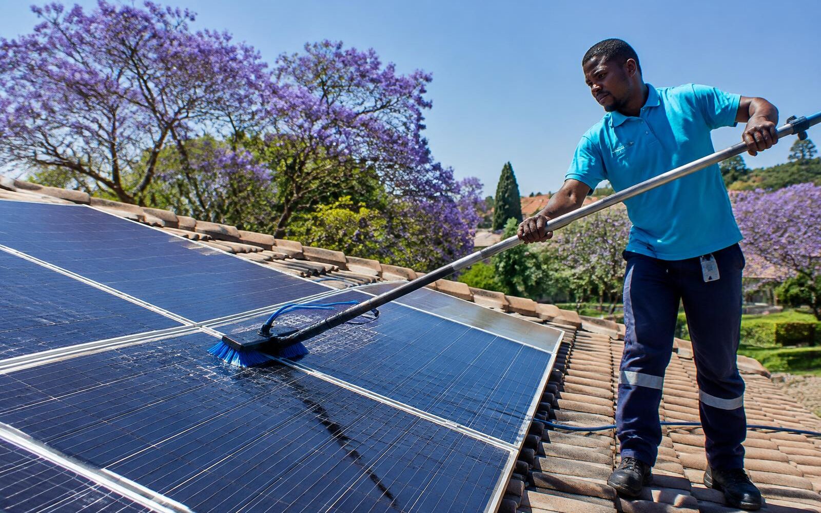 Solar panels being washed on a tiled Randburg roof