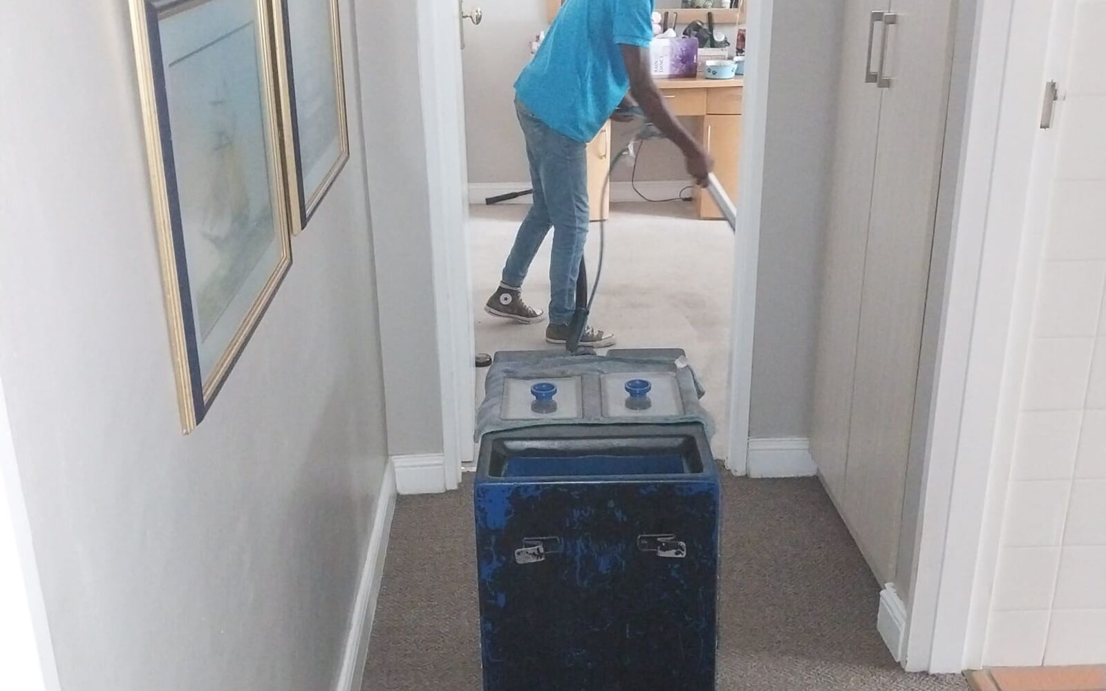 Team member cleaning carpets in a family home